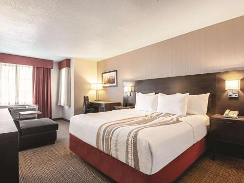 a hotel room with a large bed and a chair at La Quinta Inn by Wyndham Vancouver Airport in Richmond