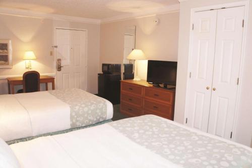 a hotel room with two beds and a flat screen tv at La Quinta Inn by Wyndham Omaha West in Omaha