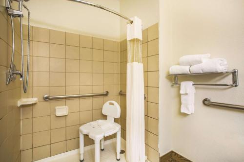 a bathroom with a toilet and a shower and a stool at La Quinta by Wyndham Fruita in Fruita