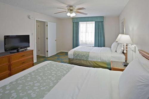 a hotel room with two beds and a flat screen tv at La Quinta Inn by Wyndham Omaha West in Omaha