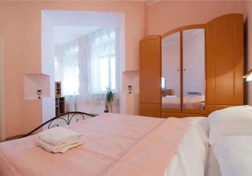 a bedroom with a large bed and a mirror at Home Hotel Apartments on Mykhailivska Square - Kiev in Kyiv
