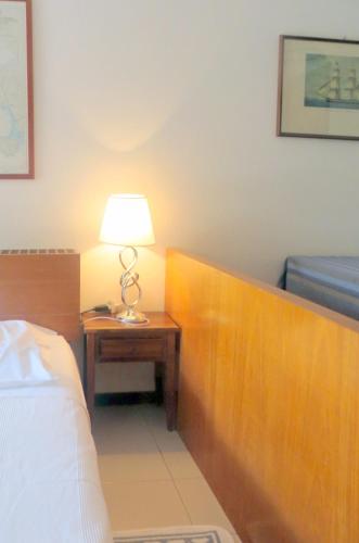 a bedroom with a bed and a table with a lamp at Appartamenti Boboli in Punta Ala
