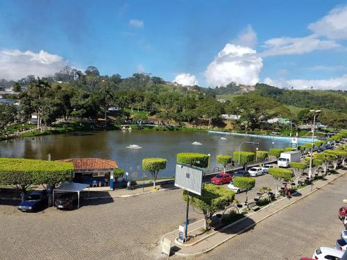 a view of a lake with cars parked in a parking lot at HOTEL FLUMINENSE in Gandu