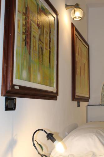 una habitación con una pintura en la pared y una lámpara en enrica barrani room, en Vernazza
