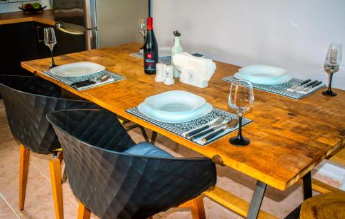 a wooden table with plates and wine glasses on it at Villa-Maria in Triopetra