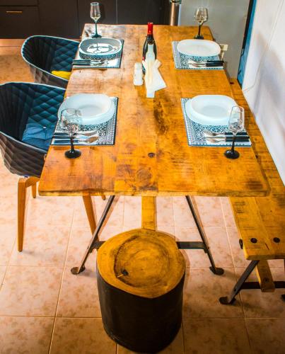 a wooden table with plates and wine glasses on it at Villa-Maria in Triopetra