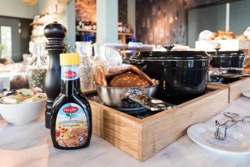 a bottle of beer and a tray of food on a counter at Hotel Kaap West I Kloeg Collection in Westkapelle