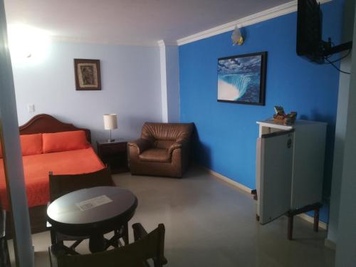 a living room with a bed and a chair and a table at HOTEL COSTA DEL SOL FUSAGASUGa in Fusagasuga