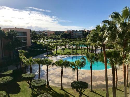 a view of a pool with palm trees at Salgados Beach Apartment 6A in Albufeira