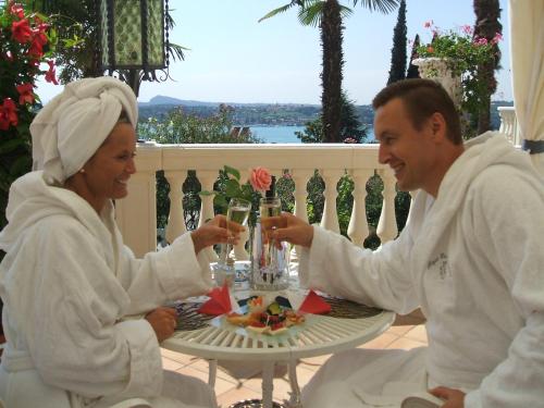 two people sitting at a table with glasses of champagne at Park Hotel Ville Montefiori in Gardone Riviera