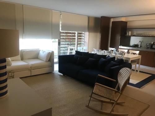 a living room with a couch and a table and chairs at Salgados Beach Apartment 6A in Albufeira