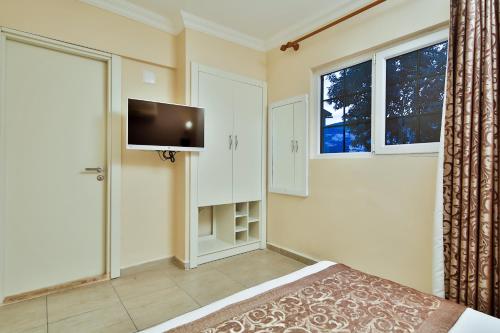 a bedroom with a bed and a tv on the wall at Enda Boutique Hotel Kalkan in Kalkan