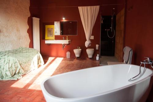 a bathroom with a bath tub and a bed at Corte Mantovanella in SantʼAntonio