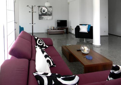 Sala de estar con sofá púrpura y mesa de centro en Mariandy 1, en Bahía de Coral