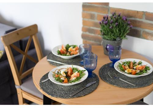 a wooden table with two plates of food on it at Gostynin Garden Apartment in Gostynin