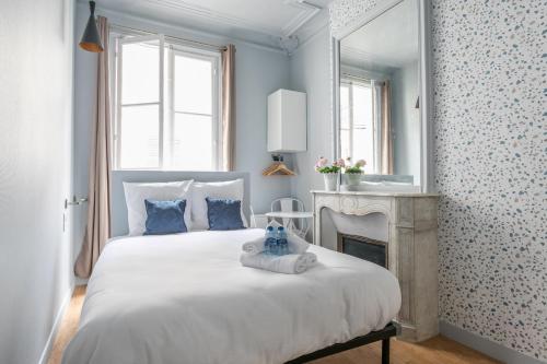 - une chambre avec un lit avec un miroir et une cheminée dans l'établissement WS Saint-Lazare - Opera, à Paris