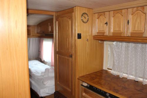 ブレンゾーネにあるCamping Denisのベッドと木製キャビネット付きの小さな部屋です。
