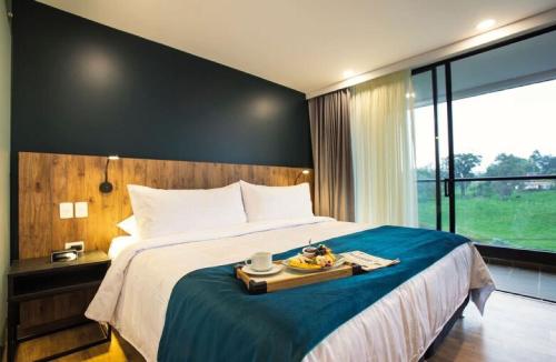 a hotel room with a bed with a tray of food on it at Hotel Lagoon in Rionegro