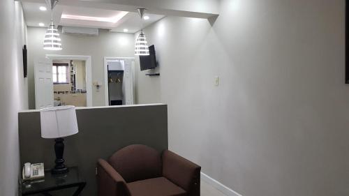a waiting room with a chair and a mirror at Christar Villas Hotel in Kingston