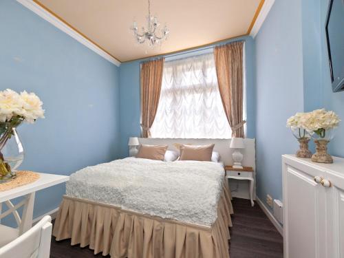 a bedroom with blue walls and a bed with a window at Cathedral Prague Apartments in Prague