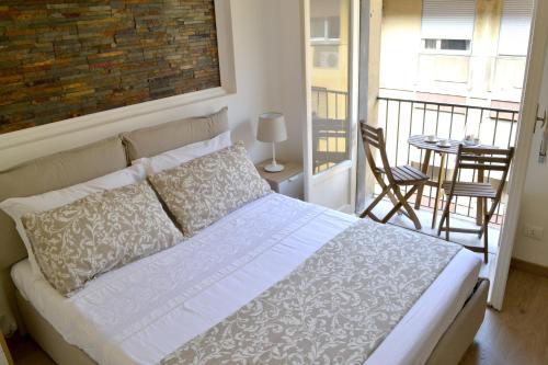 a bedroom with a bed and a balcony with a table at Modarno Exclusive Apartments in Florence