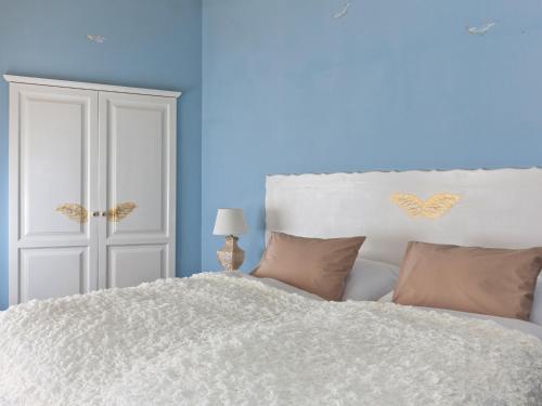 a bedroom with a white bed with blue walls at Cathedral Prague Apartments in Prague