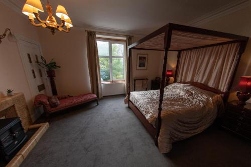 a bedroom with a canopy bed and a window at Period House / Entire Upstairs Flat in Inverness