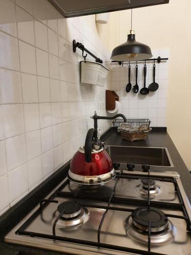 a red tea kettle on a stove in a kitchen at Il Nido del Cuculo in Petrignano