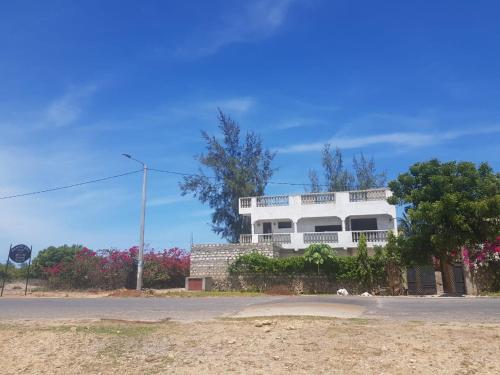 a white house on the side of a road at Nyumba Tulivu in Watamu