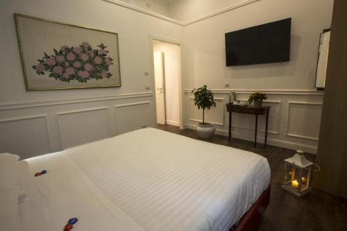 a bedroom with a bed and a flat screen tv at Promenade Maison de Charme in Sanremo