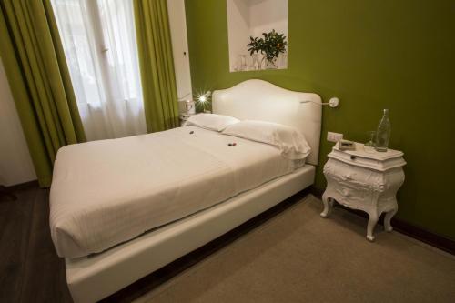 a bedroom with a white bed and a green wall at Promenade Maison de Charme in Sanremo