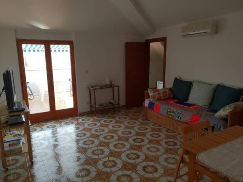 a living room with a couch and a tv at Palazzo Ionio in Scalea