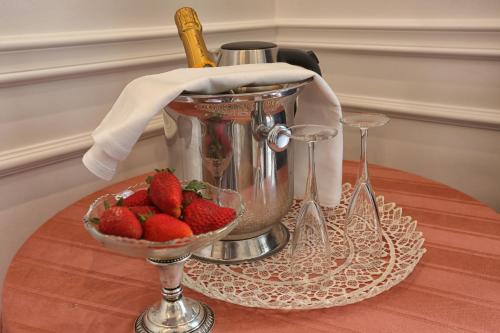 a bowl of strawberries sitting on a table with a bucket at Promenade Maison de Charme in Sanremo