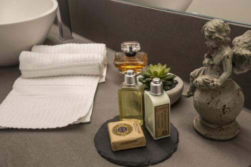 a bathroom counter with a bottle of perfume and a towel at Promenade Maison de Charme in Sanremo