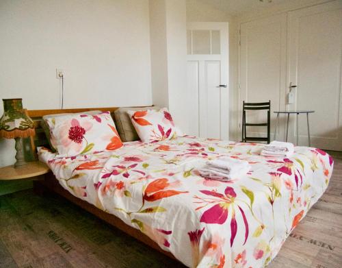 een slaapkamer met een bed met een bloemdekbed bij B&B “Te Warskip bij BlokVis” in Medemblik