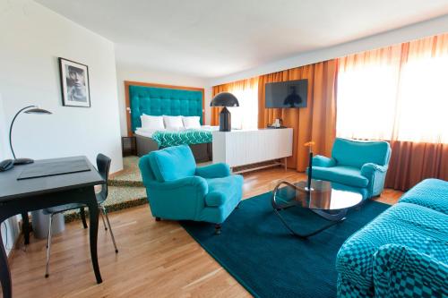 a hotel room with two beds and blue chairs at Quality Hotel Grand, Borås in Borås