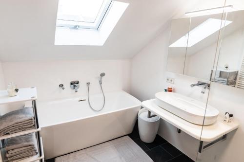 biała łazienka z umywalką i wanną w obiekcie Skyview Studio STP w mieście Sankt Pölten