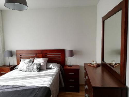 - une chambre avec un lit, une commode et un miroir dans l'établissement MESONES 7, à Villanubla