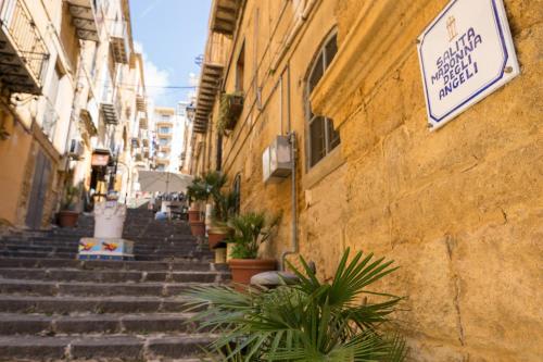 un grupo de escaleras en un callejón con plantas en B&B Salotto Di Athena en Agrigento