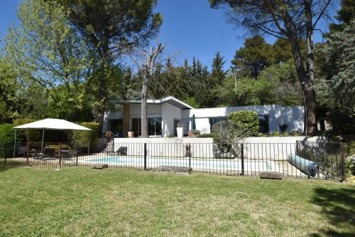 a house with a fence in front of a yard at suite indépendante au calme avec piscine in Aix-en-Provence