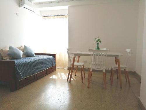 1 dormitorio con mesa, cama, mesa y sillas en Departamento de la calle 50, en La Plata