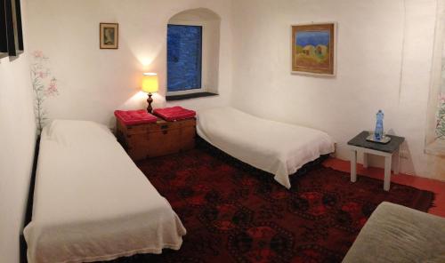 a room with two beds and a table with a lamp at Old Oilmill near Dolcedo in Dolcedo