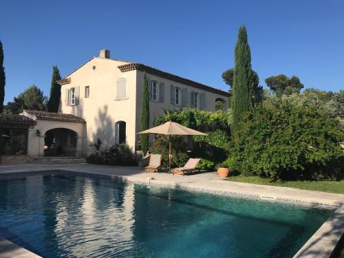 a house and a swimming pool in front of a house at LES BARTAVELLES in Aix-en-Provence