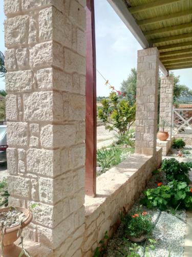 an outside wall of a house with a stone wall at Εmmi in Koutsounari