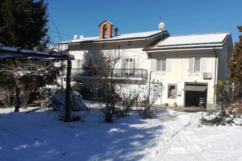 Biały dom z śniegiem przed nim w obiekcie suite in cascina affittacamere w mieście Casalborgone