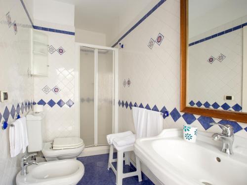 uma casa de banho com um lavatório, um WC e um espelho. em B&B Armonia em Siracusa