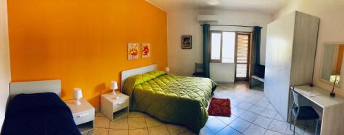 um quarto com uma cama verde e paredes cor-de-laranja em B&B Serena em Longi