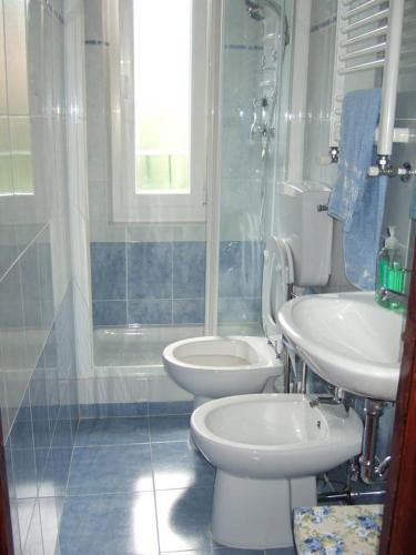 a bathroom with two toilets and a shower and a sink at Brezza Marina in Portovenere
