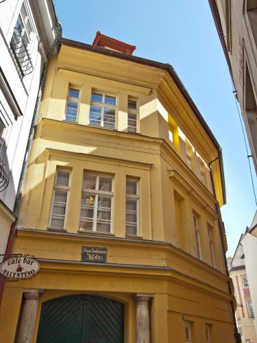 a yellow building with windows on a street at Cathedral Prague Apartments in Prague