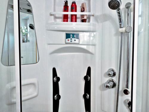 a white shower door with bottles on it at Adria Apartments and Rooms in Dubrovnik